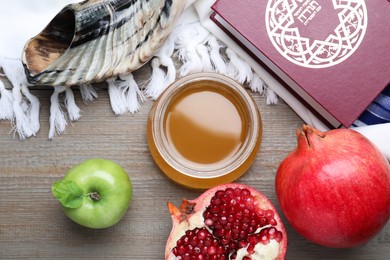 Honey, pomegranate, apples, shofar and Torah on wooden table, flat lay. Rosh Hashana holiday
