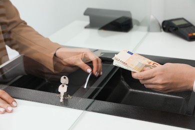 Man giving money to cashier in bank, closeup. Currency exchange