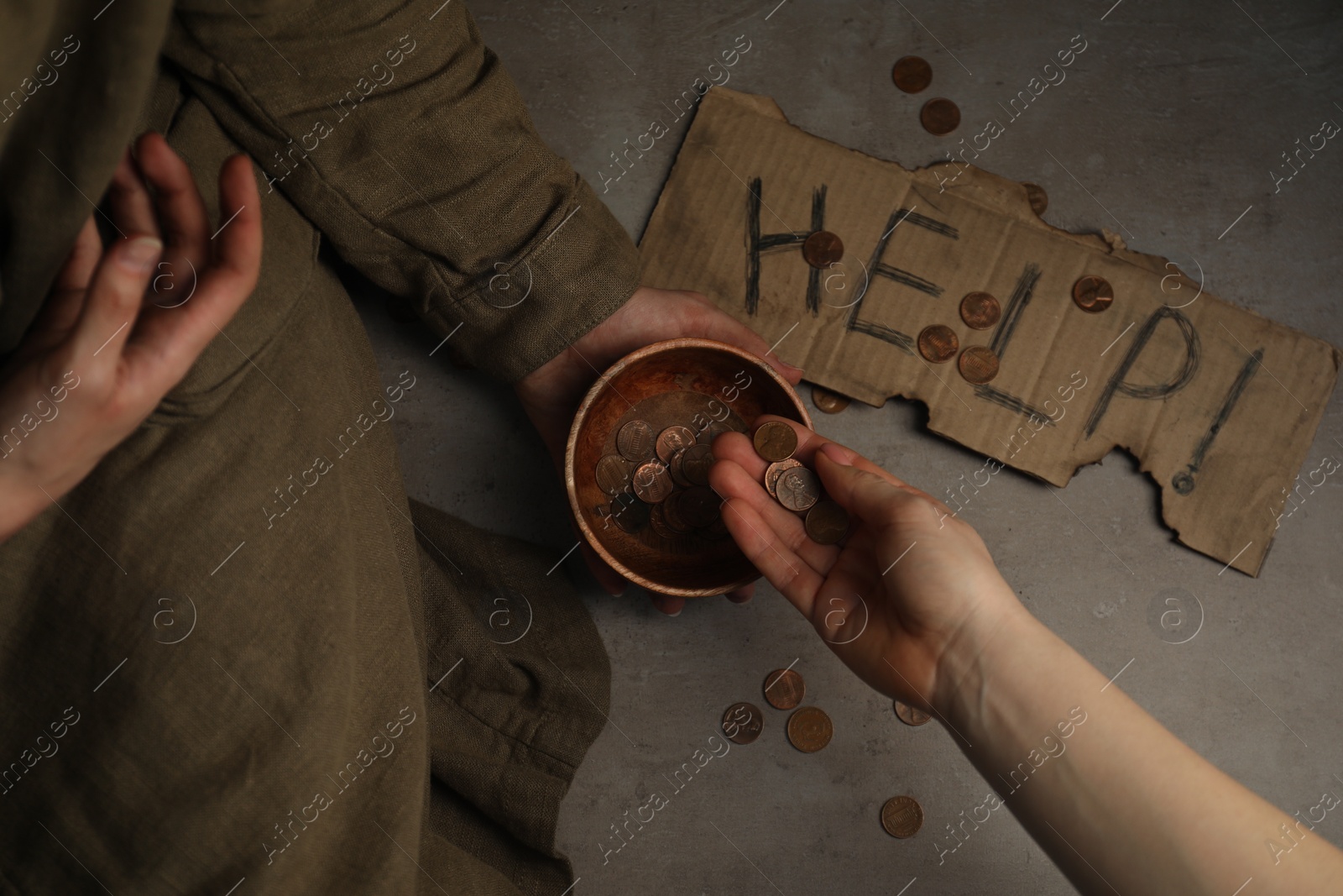 Photo of Woman giving coins to homeless, top view. Charity and donation