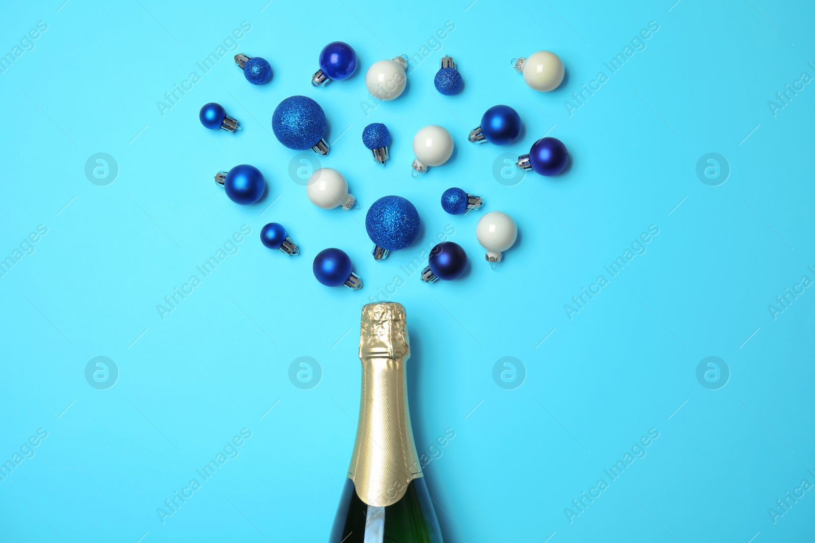 Photo of Creative flat lay composition with champagne and decorative balls on color background