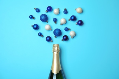 Photo of Creative flat lay composition with champagne and decorative balls on color background