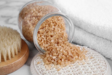 Photo of Jar with salt for spa scrubbing procedure on white marble table