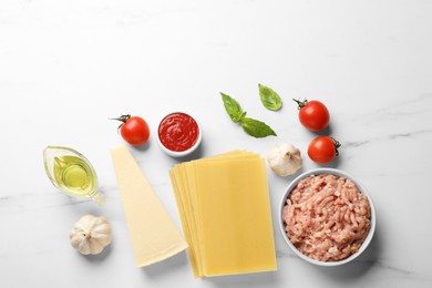 Ingredients for lasagna on white marble table, flat lay
