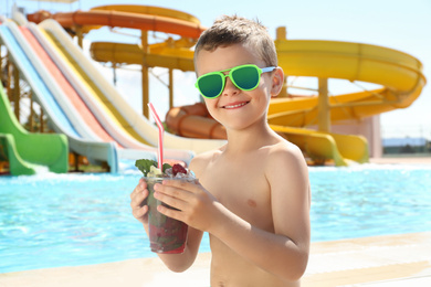 Boy with delicious refreshing drink in water park