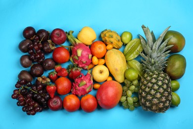 Photo of Assortment of fresh exotic fruits on light blue background, flat lay