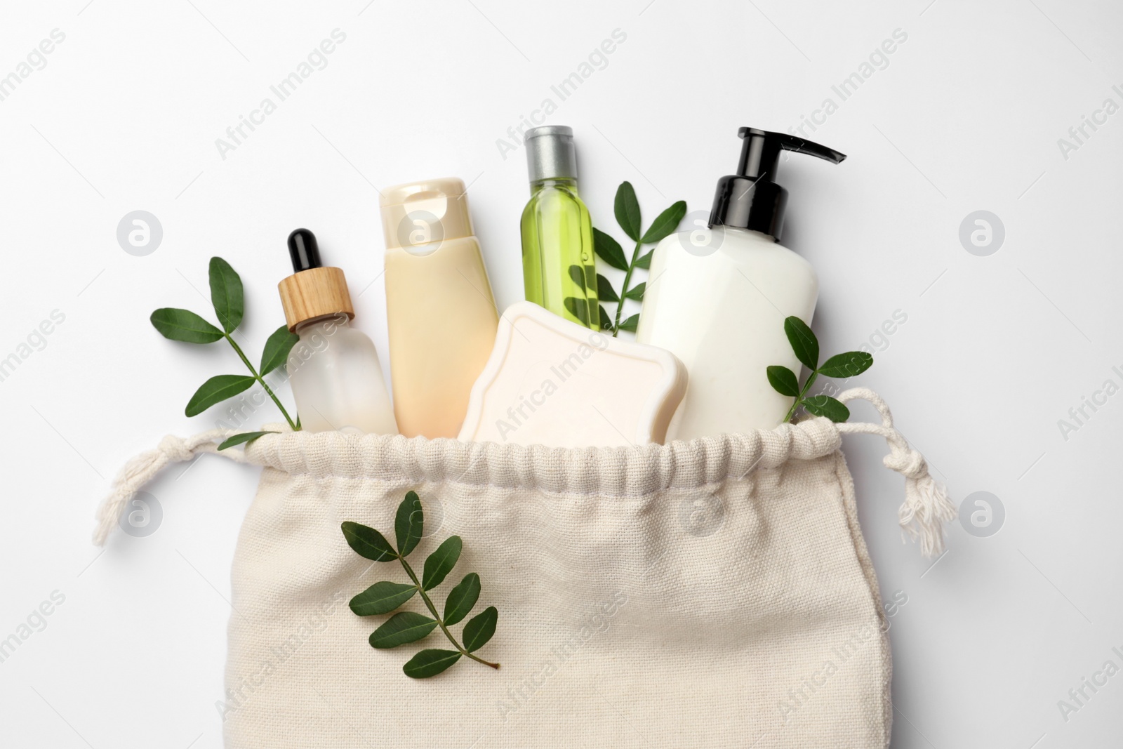 Photo of Preparation for spa. Compact toiletry bag, twigs and cosmetic products on white background, flat lay