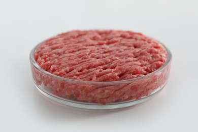 Photo of Petri dish with raw minced cultured meat on white table, closeup