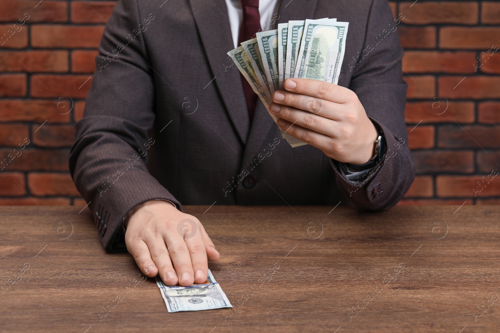 Photo of Man holding money at wooden table, closeup. Currency exchange