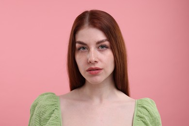 Portrait of beautiful woman with freckles on pink background