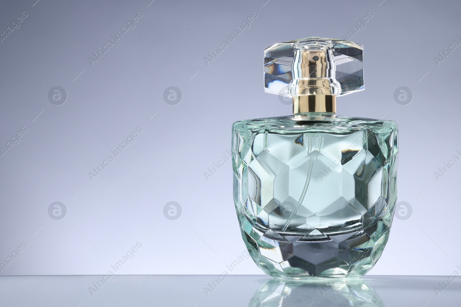 Photo of Luxury women's perfume in bottle on grey background. Space for text