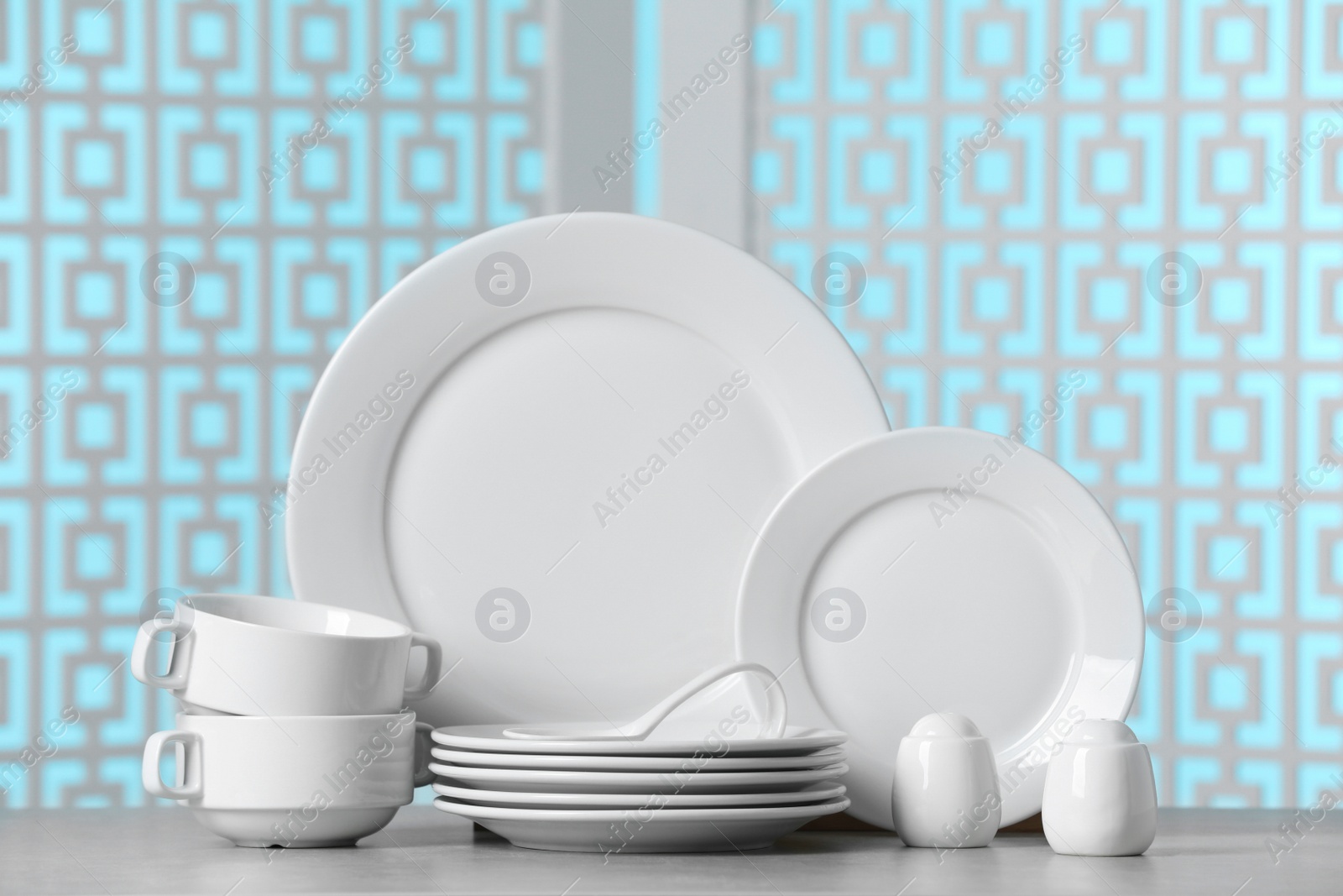 Photo of Set of clean dishware on light grey table