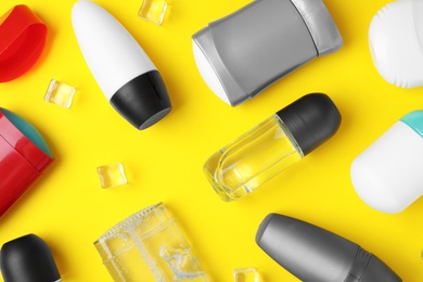 Flat lay composition with different male deodorants on yellow background