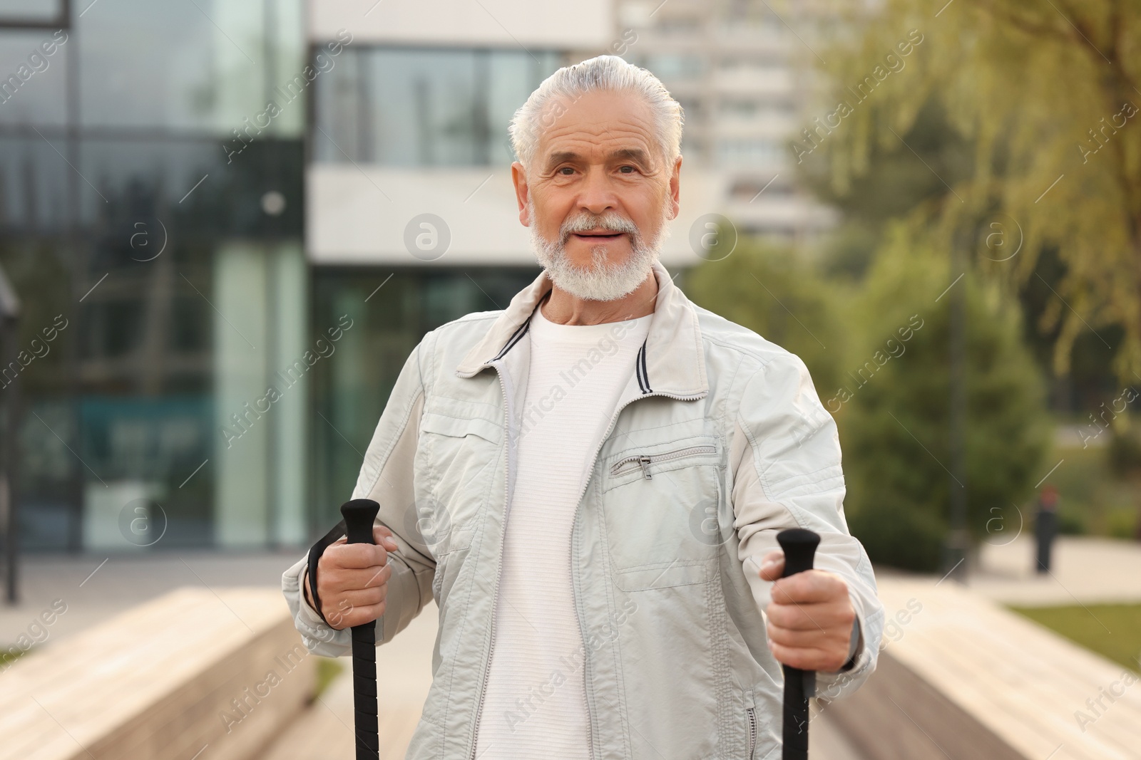 Photo of Senior man with Nordic walking poles outdoors