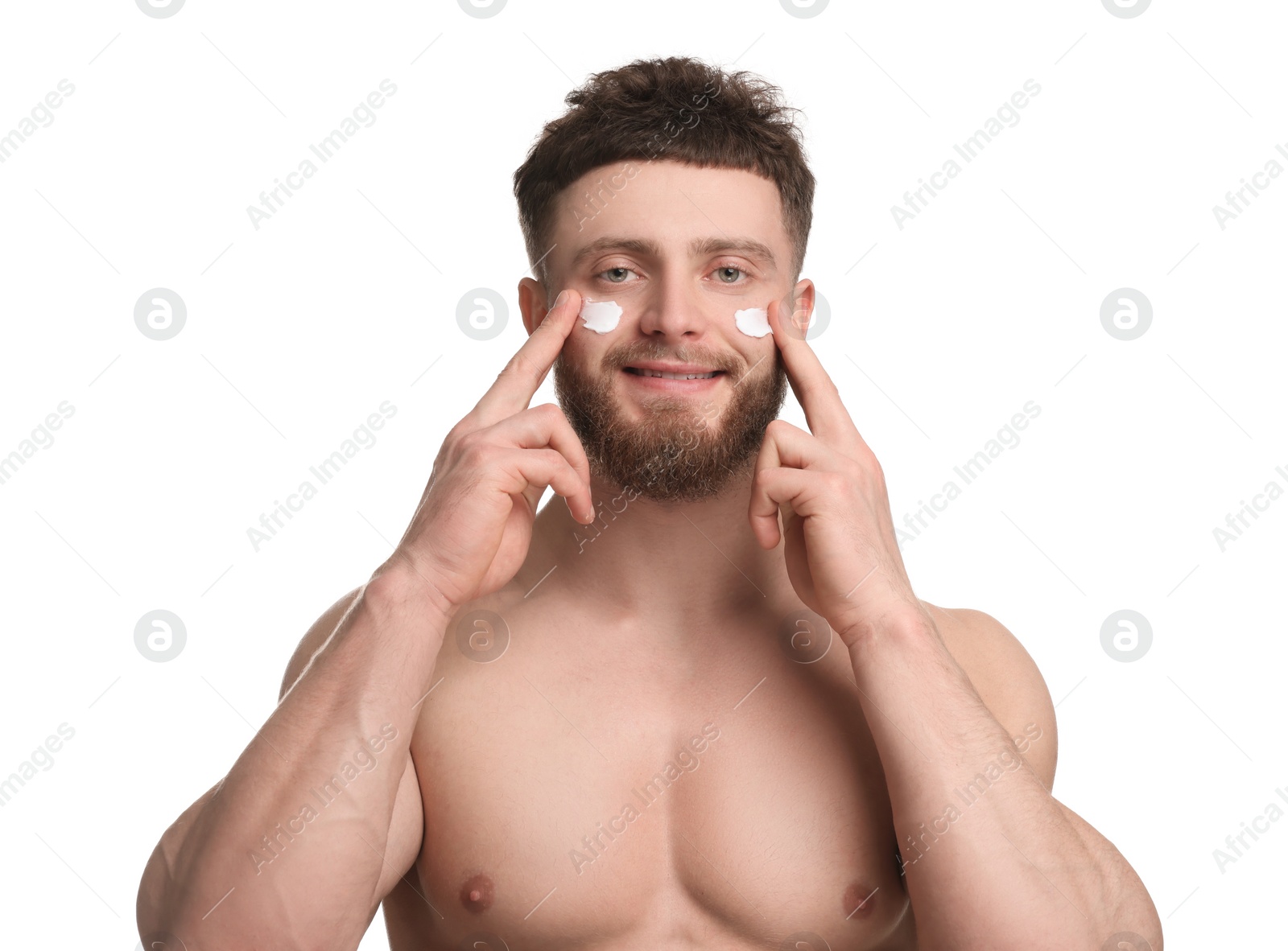 Photo of Handsome man applying moisturizing cream onto his face on white background