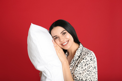 Photo of Young woman with pillow on red background