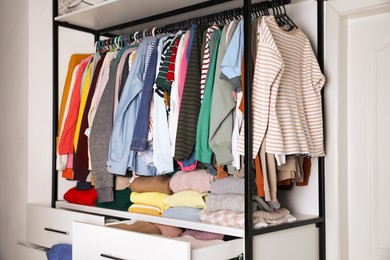 Photo of Rack with stylish women's clothes in room. Fast fashion