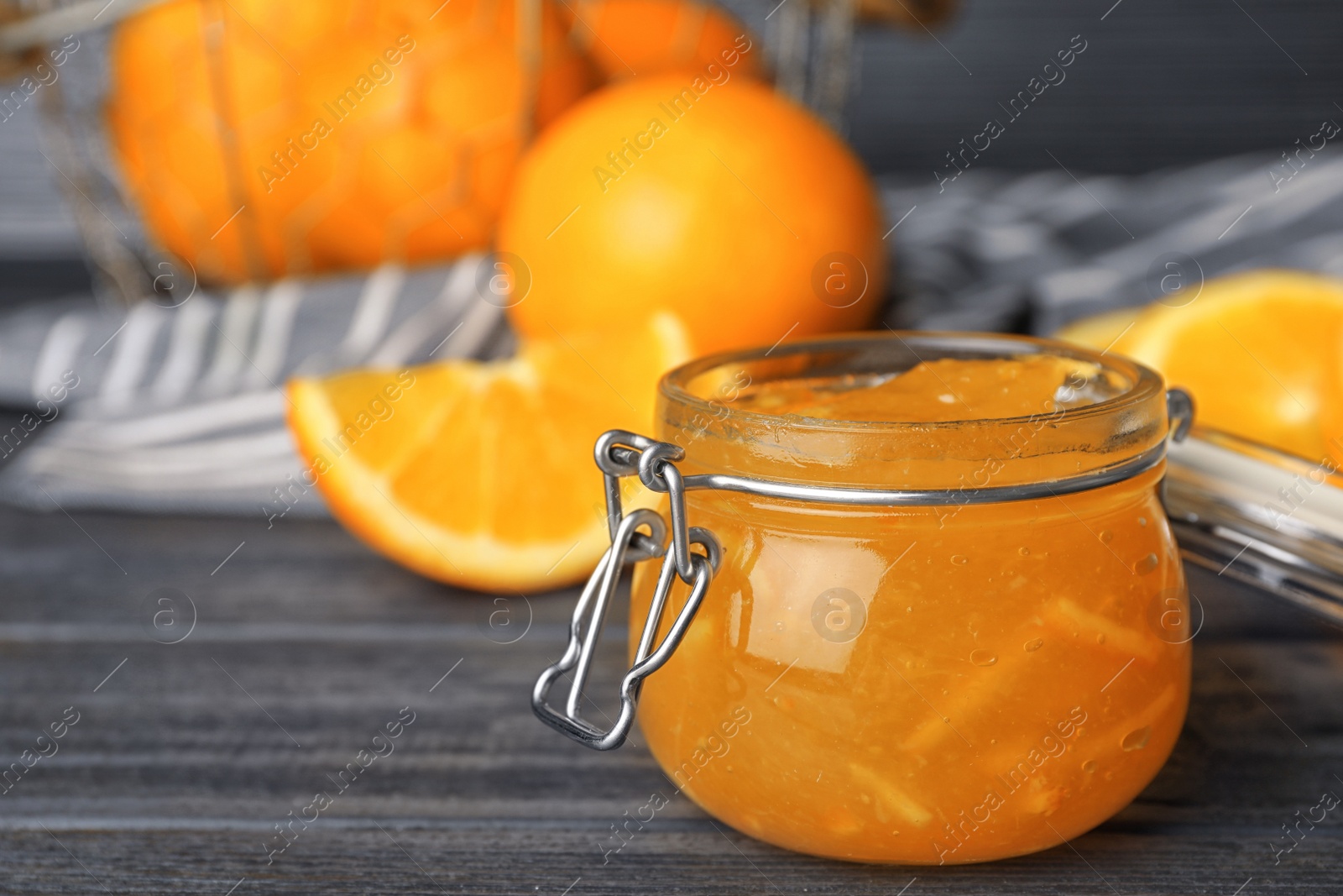 Photo of Jar of orange jam on grey wooden table