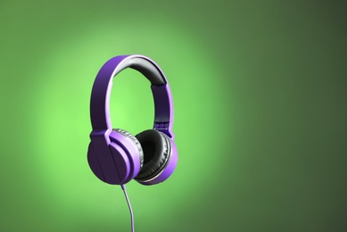 Photo of Stylish headphones on color background. Space for text