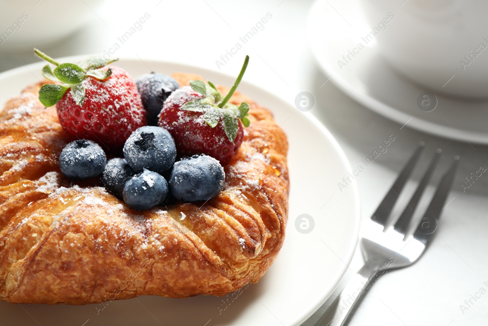 Photo of Fresh delicious puff pastry with sweet berries served on light table, closeup