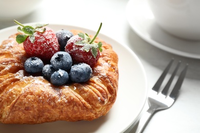 Fresh delicious puff pastry with sweet berries served on light table, closeup