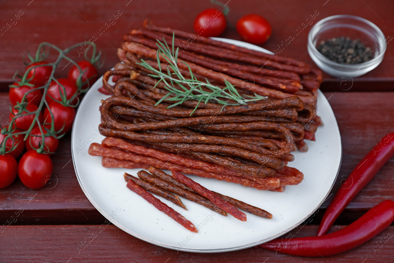 Photo of Tasty dry cured sausages (kabanosy) and ingredients on wooden table, above view