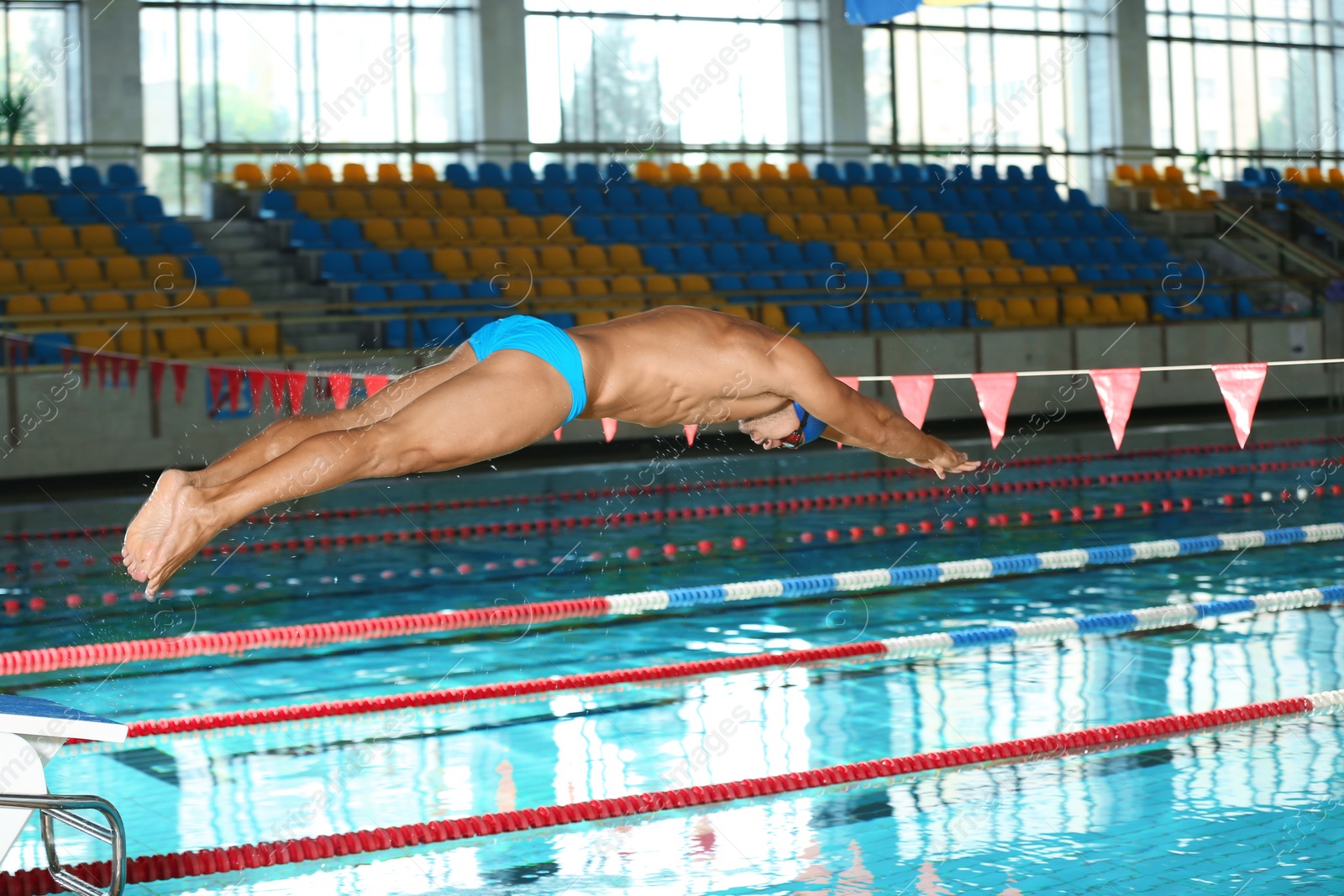 Photo of Young athletic man jumping into swimming pool