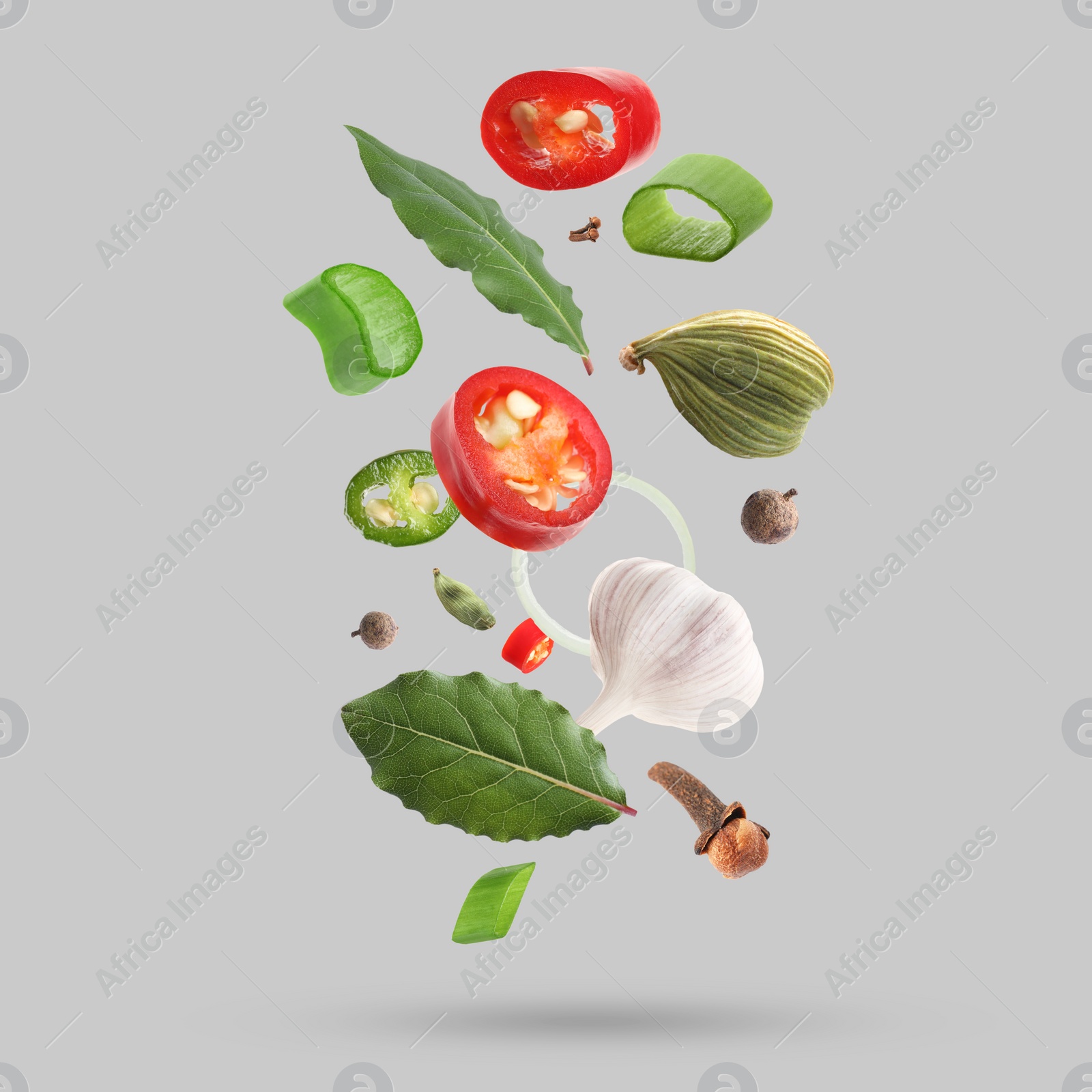 Image of Different spices falling on light grey background