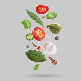 Image of Different spices falling on light grey background