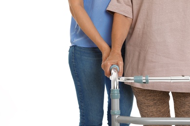Photo of Caretaker helping elderly woman with walking frame on white background, closeup