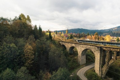 Image of Aerial view of bridge and village on autumn day