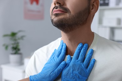 Photo of Endocrinologist examining thyroid gland of patient at hospital, closeup