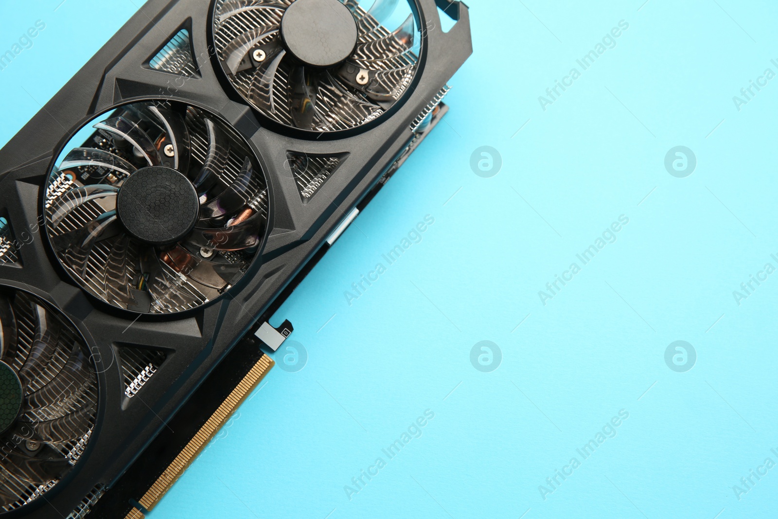 Photo of One graphics card on light blue background, top view. Space for text