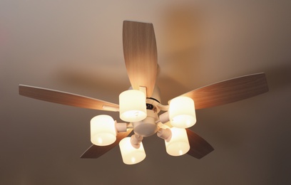 Photo of Modern ceiling fan with lamps indoors, below view