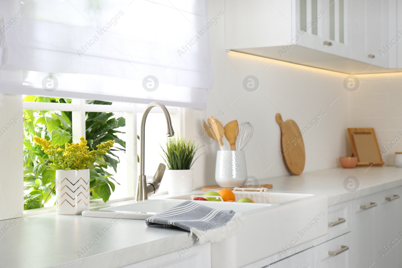 Photo of Beautiful white sink near window in modern kitchen