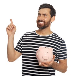 Photo of Happy man with ceramic piggy bank on white background