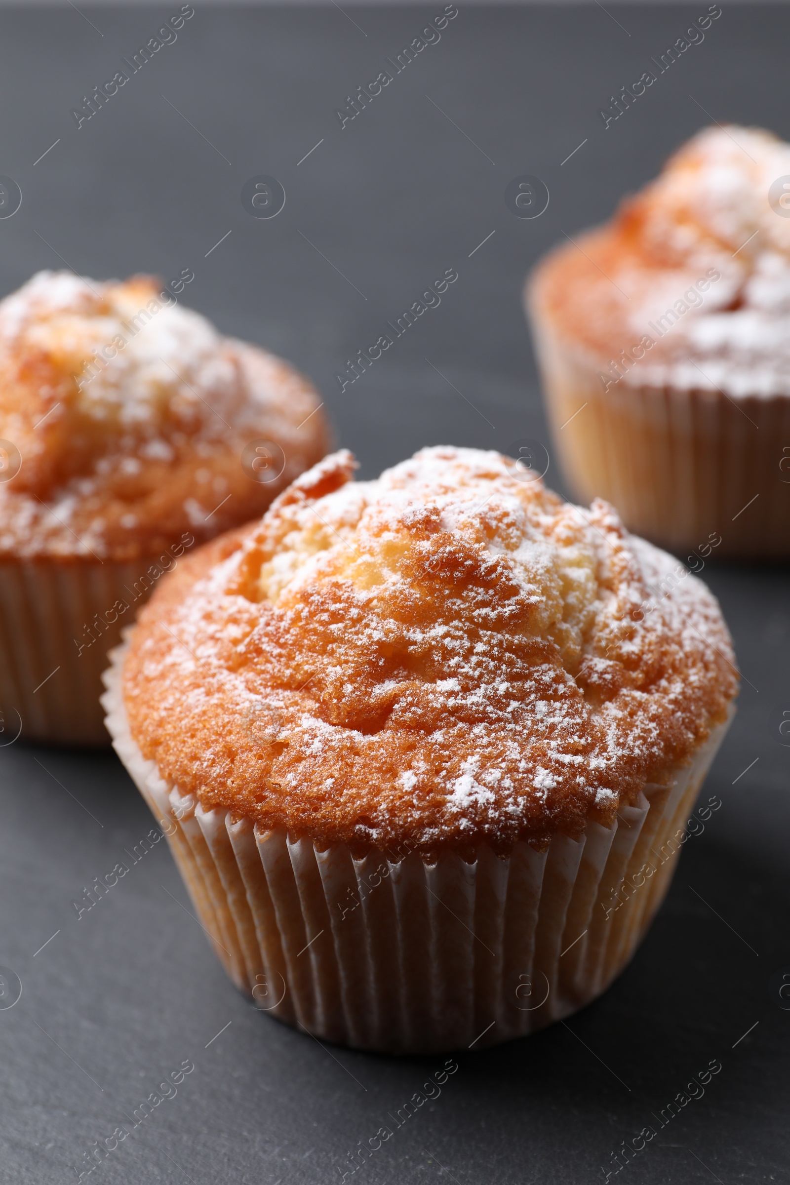 Photo of Delicious sweet muffins on black table, closeup