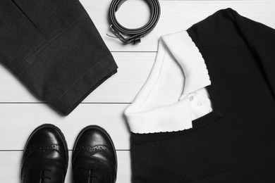 Photo of Stylish school uniform for girl on white wooden background, flat lay