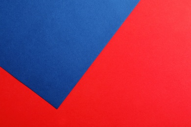 Blue and red paper sheets as colorful background, top view