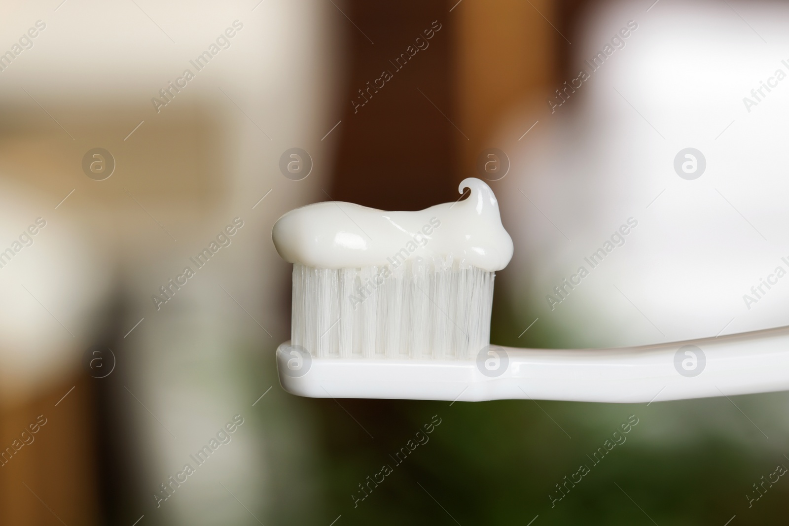 Photo of Plastic toothbrush with paste on blurred background, closeup