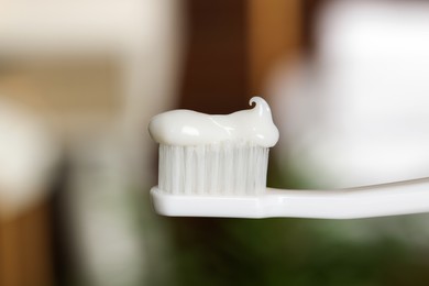 Photo of Plastic toothbrush with paste on blurred background, closeup