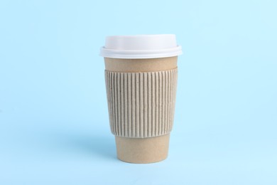 Photo of Paper cup with plastic lid on light blue background. Coffee to go