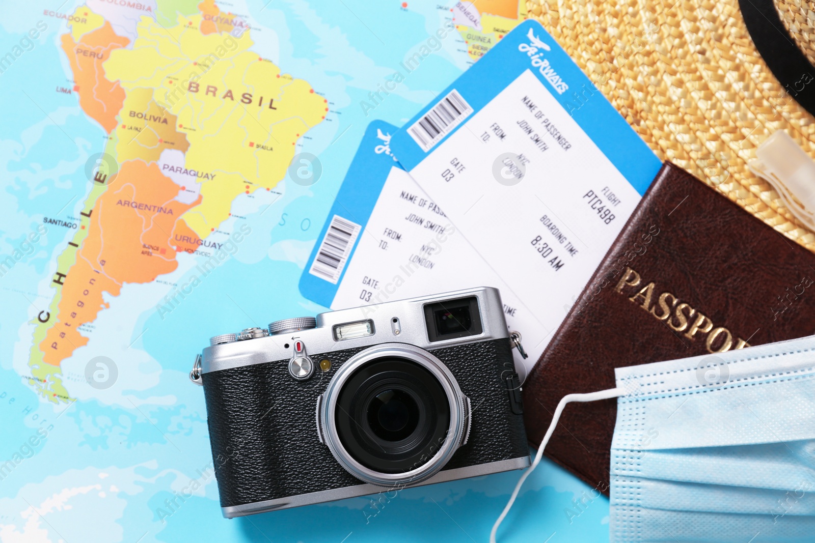 Photo of Flat lay composition with passport and protective face mask on world map. Travel during quarantine