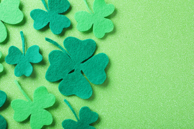 Photo of Flat lay composition with clover leaves on light green background, space for text. St. Patrick's Day celebration