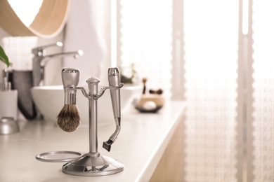 Photo of Shaving accessories on countertop in stylish bathroom