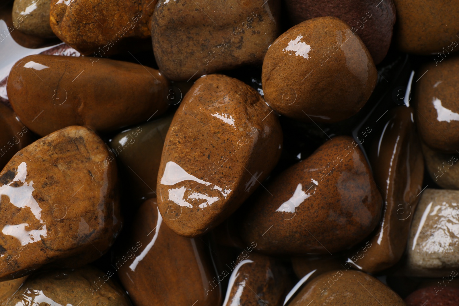 Photo of Beautiful pebbles in water as background, top view