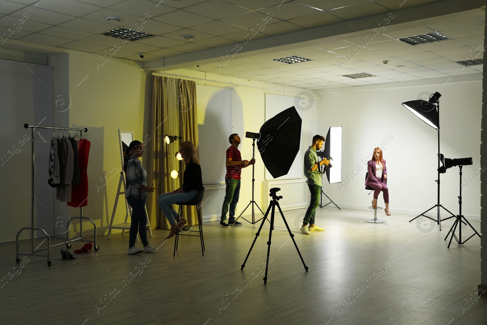 Photo of Photo studio with professional equipment and team of workers