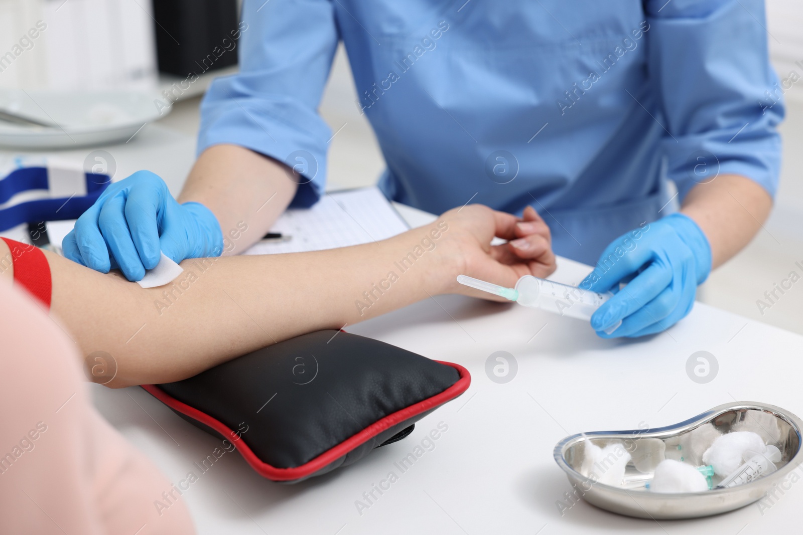 Photo of Laboratory testing. Doctor taking blood sample from patient at white table in hospital, closeup