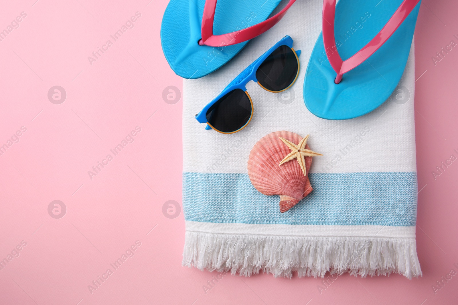 Photo of Flat lay composition with beach accessories on pink background, space for text