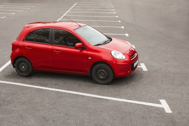 Photo of Modern red car on parking lot outdoors