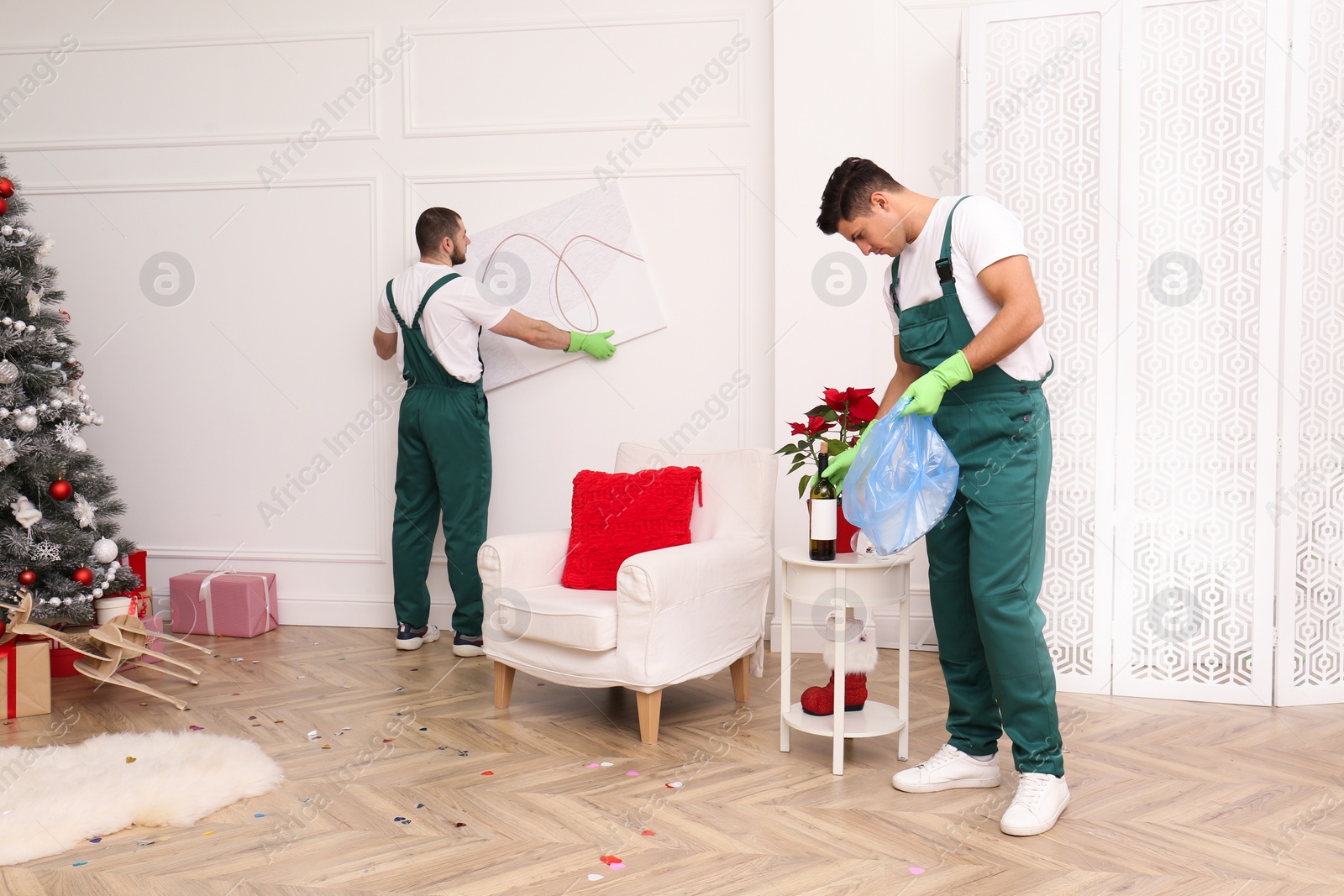 Photo of Cleaning service team working in messy room after New Year party